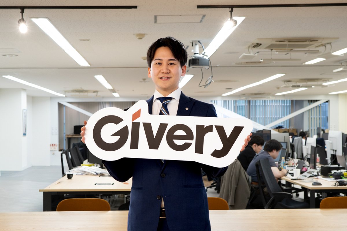 オフィスでロゴを持つギブリーの社員