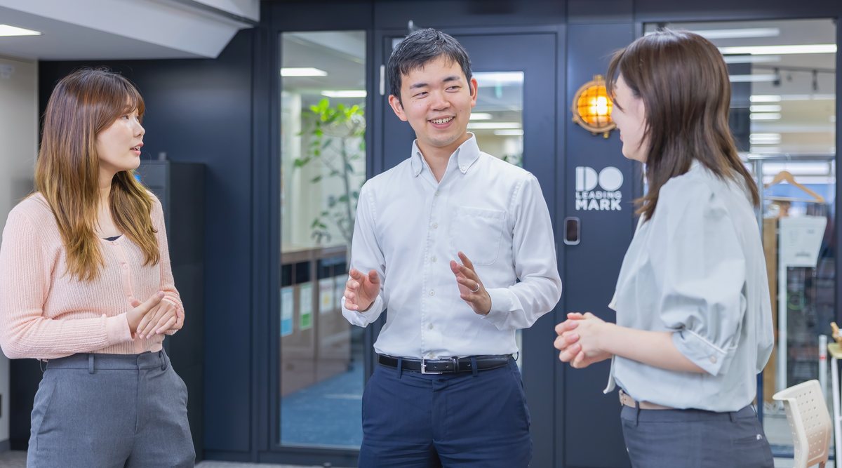 リーディングマークのオフィスで話す社員